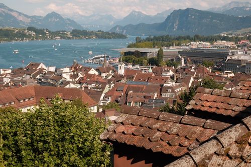 Free A scenic view of Lucerne, Switzerland, showing rooftops, Lake Lucerne, and mountains. Stock Photo