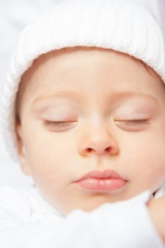 Adorable baby peacefully sleeping close-up with eyes closed, exuding innocence.