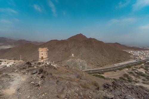Free Aerial view of a historic fort near Khor Fakkan, UAE, amidst rocky mountains and clear skies. Stock Photo