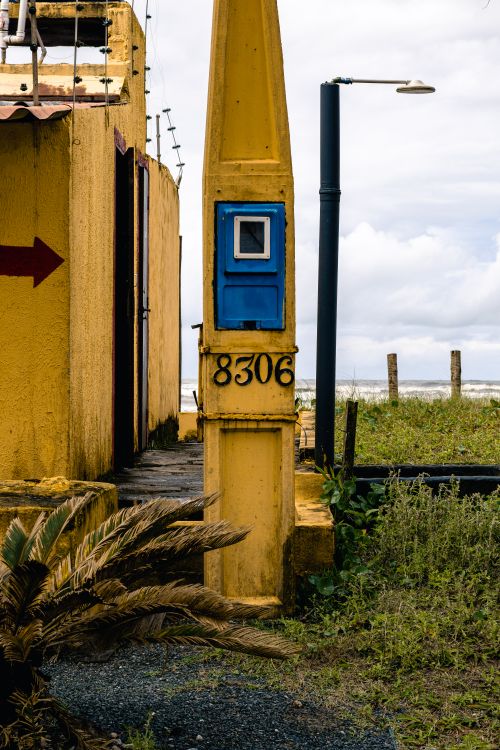 Free Yellow building with numbers and blue panel near the beach in Peruíbe, São Paulo, Brazil. Stock Photo
