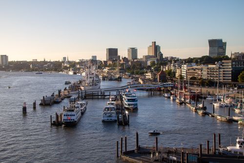 Free Discover the bustling Hamburg port with its picturesque skyline and vibrant waterfront activity. Stock Photo