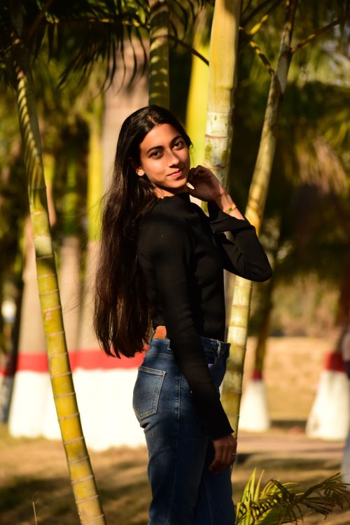 Free Stylish female posing outdoors in casual attire with natural background in India. Stock Photo