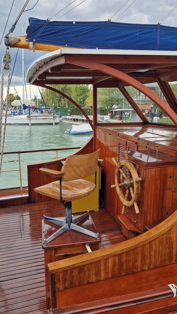 The cockpit and wooden helm of a sailing boat