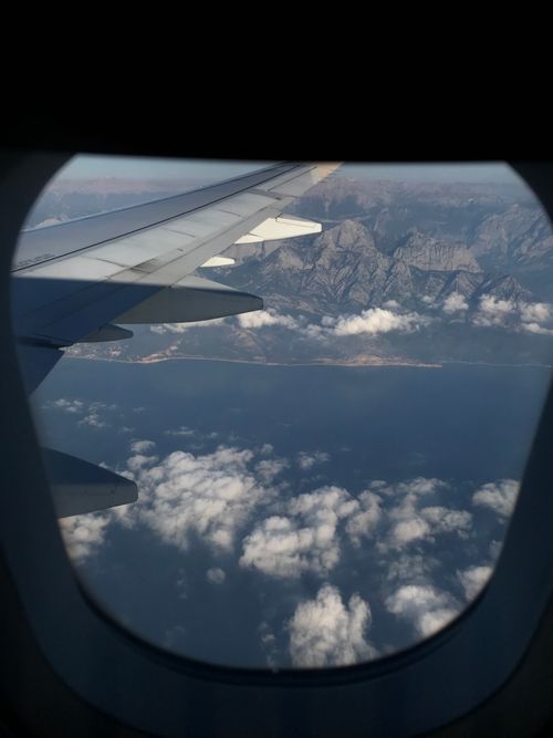Free Scenic aerial view from an airplane window capturing Türkiye's coastline and mountains. Stock Photo