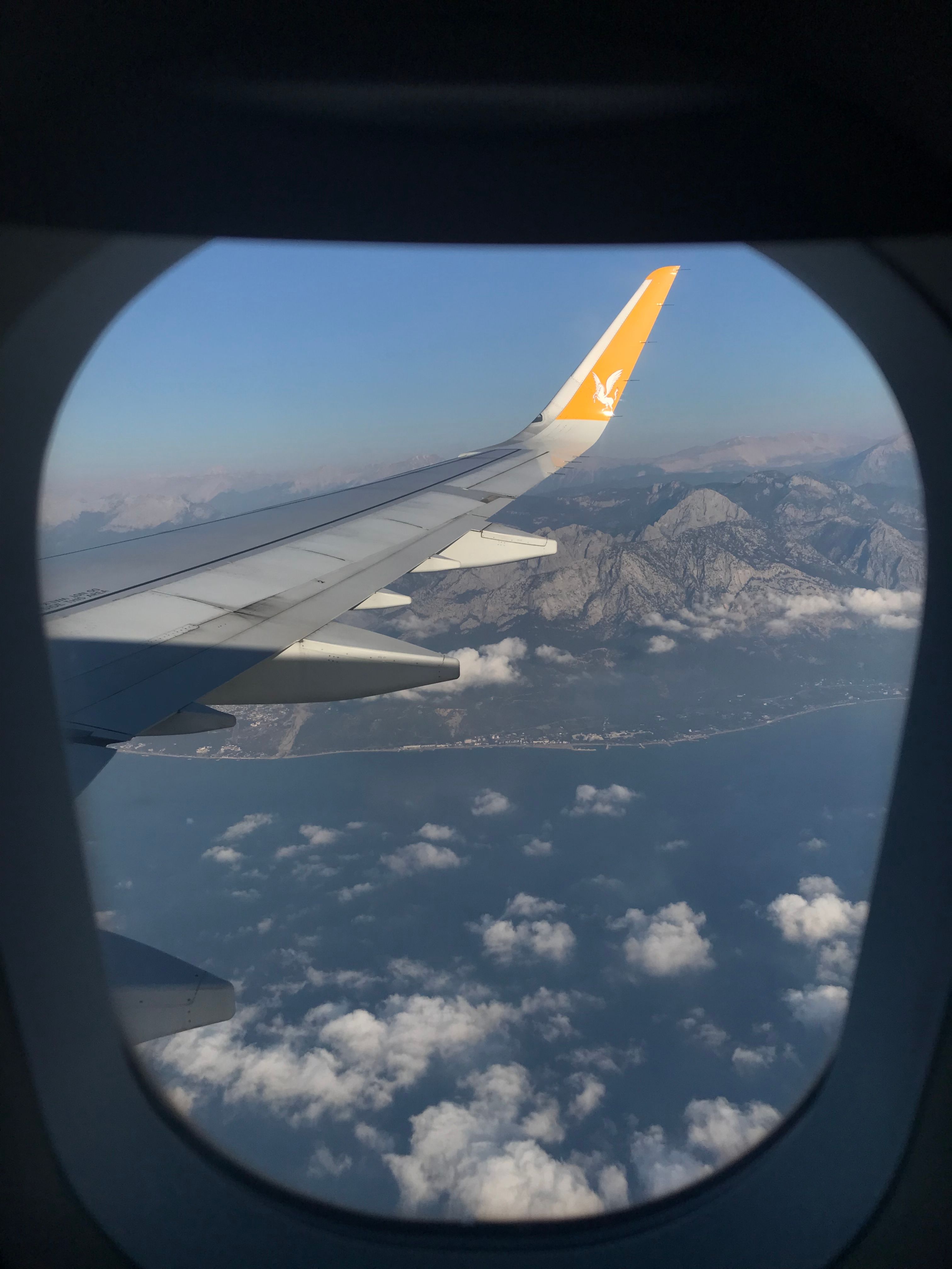 A stunning aerial view from a plane over Türkiye showcasing cloud formations and mountainous terrain.