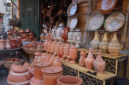 Free Colorful array of traditional ceramic pottery at an outdoor market stall. Ideal for cultural and artisan themes. Stock Photo