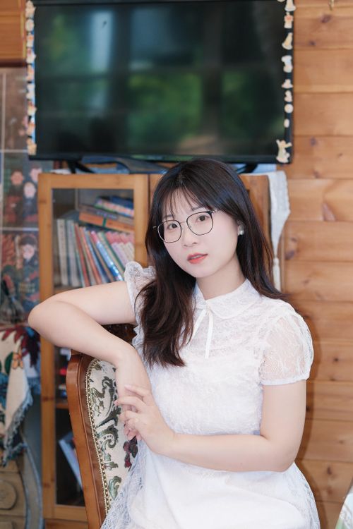 Free Portrait of a woman in a white lace dress indoors in Hefei, China. Stock Photo
