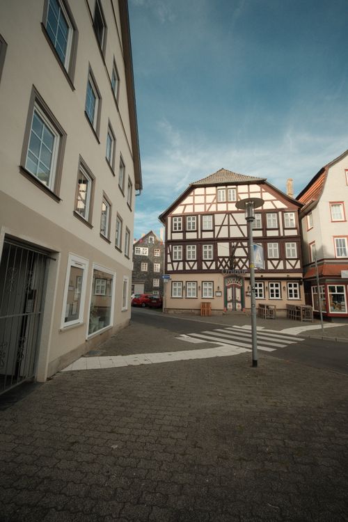 Free Explore the historic charm of cobblestone streets in Bad Hersfeld's old town under a clear sky. Stock Photo