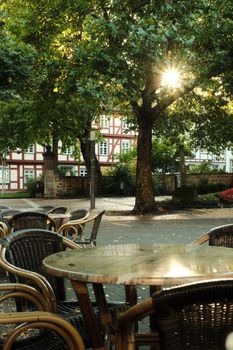 Sun-dappled plaza in Bad Hersfeld featuring historic buildings and outdoor seating.