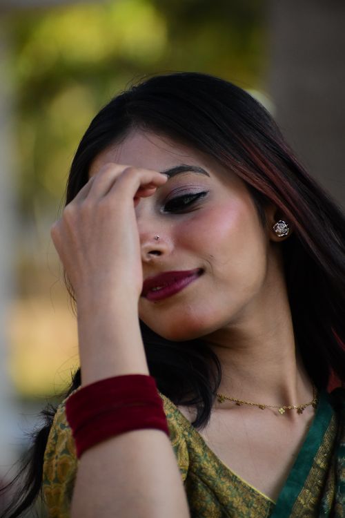 Free Close-up portrait of a South Asian woman in a green saree outdoors, showcasing traditional style. Stock Photo