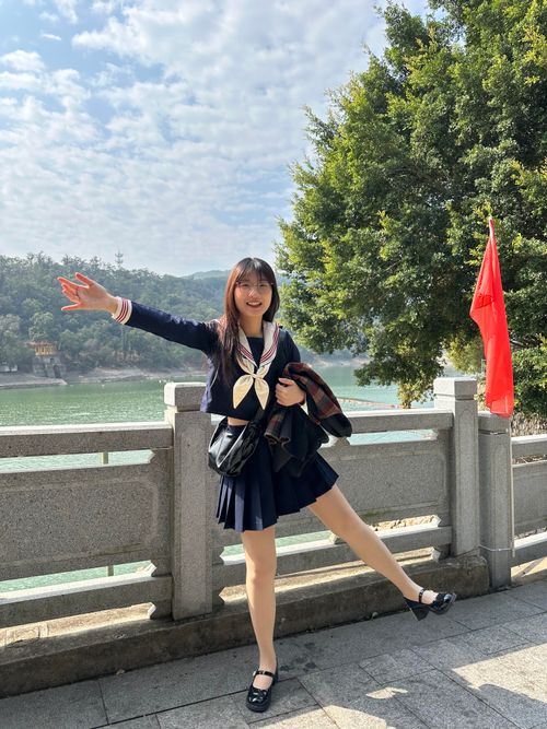 Free A cheerful young woman in a school uniform poses with a scenic lake backdrop in Hefei, China. Stock Photo