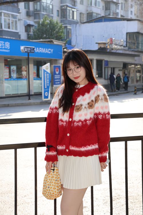 Free A young woman with glasses wears a red sweater, standing outdoors in Hefei, China. Stock Photo