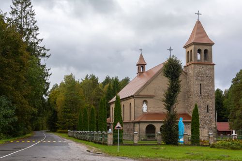 Free A serene scene of a historic church in Idolta, Belarus, surrounded by autumn woods. Stock Photo