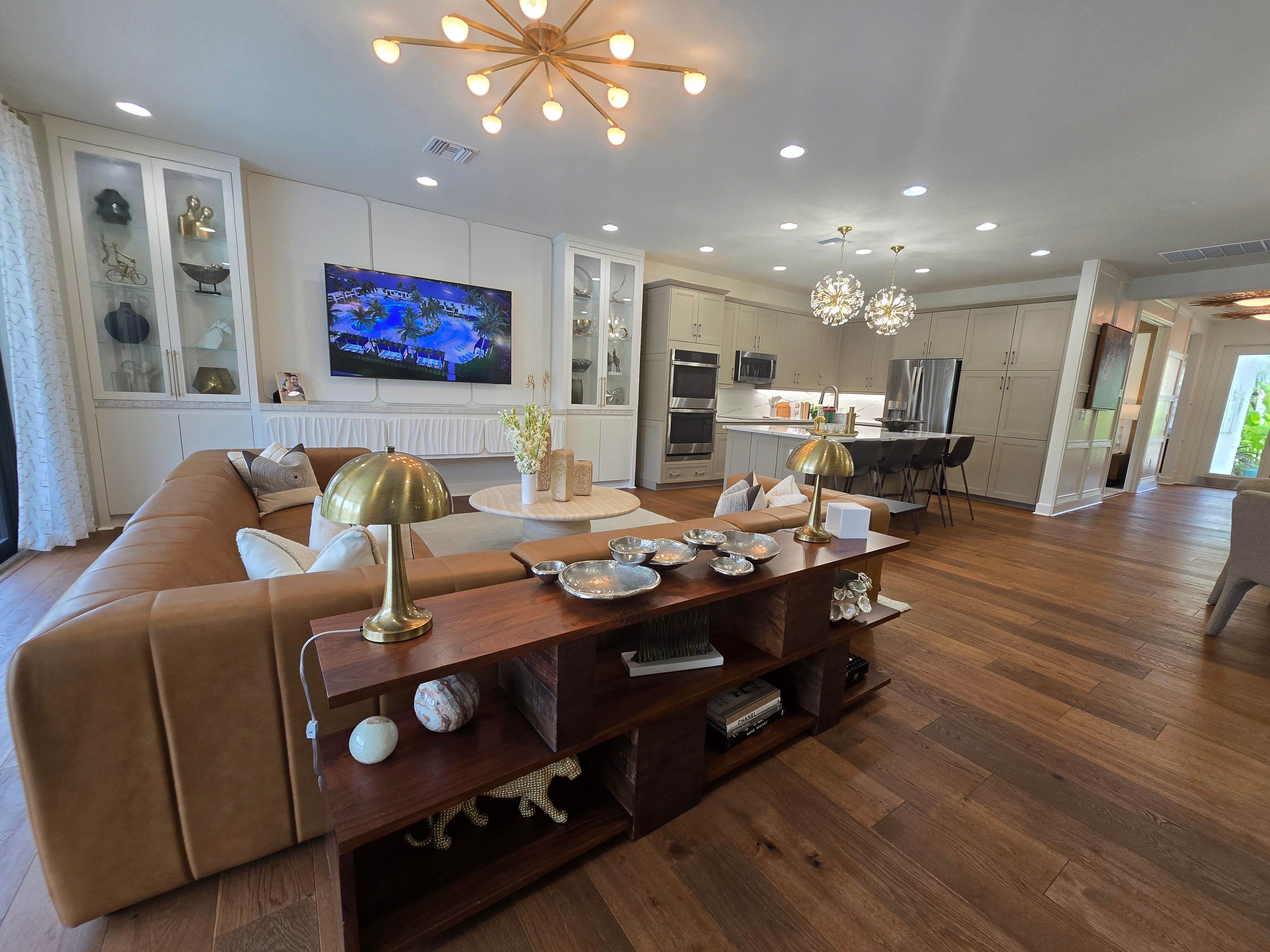 Spacious modern living room and kitchen with stylish decor and wooden flooring.