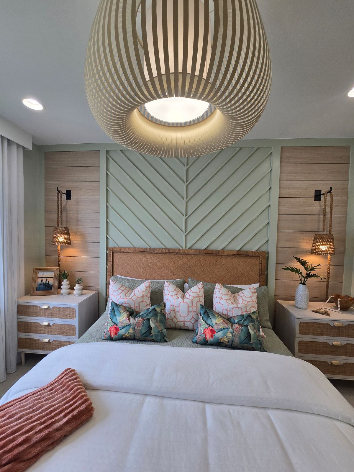 Modern bedroom with chevron walls, elegant lighting, and plush bedding for a cozy home vibe. Stock Photo.