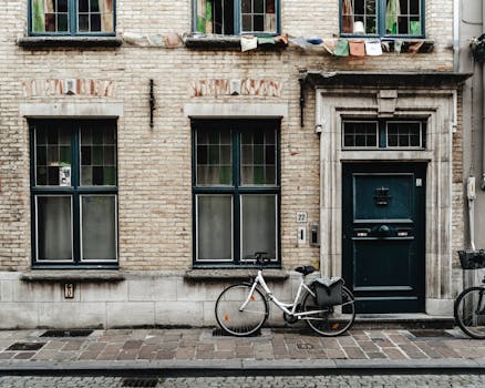 Historic brick facade with a bicycle in Ghent, Belgium, displaying classic European architecture. by Viktor Mogilat