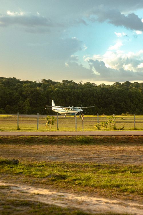 Free A small private airplane sits on a rural airstrip near the forest in Breves, Brazil, under a cloudy sky. Stock Photo