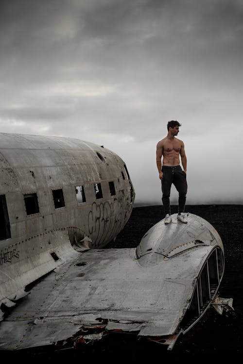 Free Man Standing On Airplane Wreckage Stock Photo