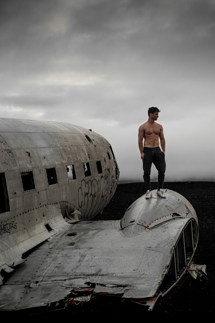 Man Standing On Airplane Wreckage