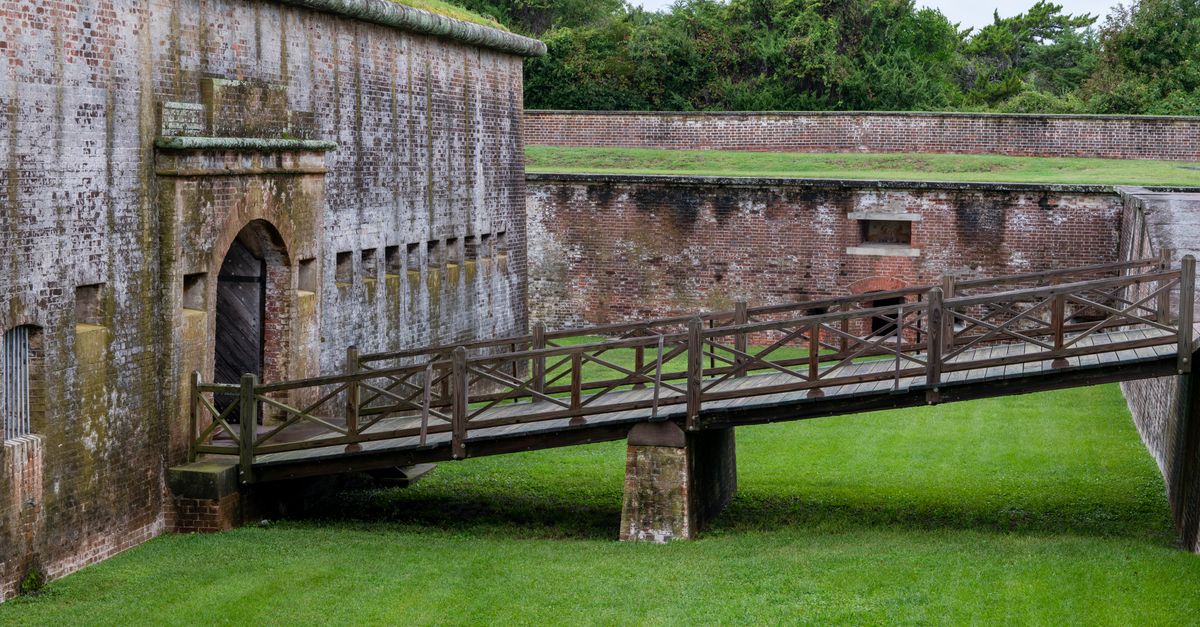 View of the historic entrance and bridge at Fort Macon, showcasing classic architecture.