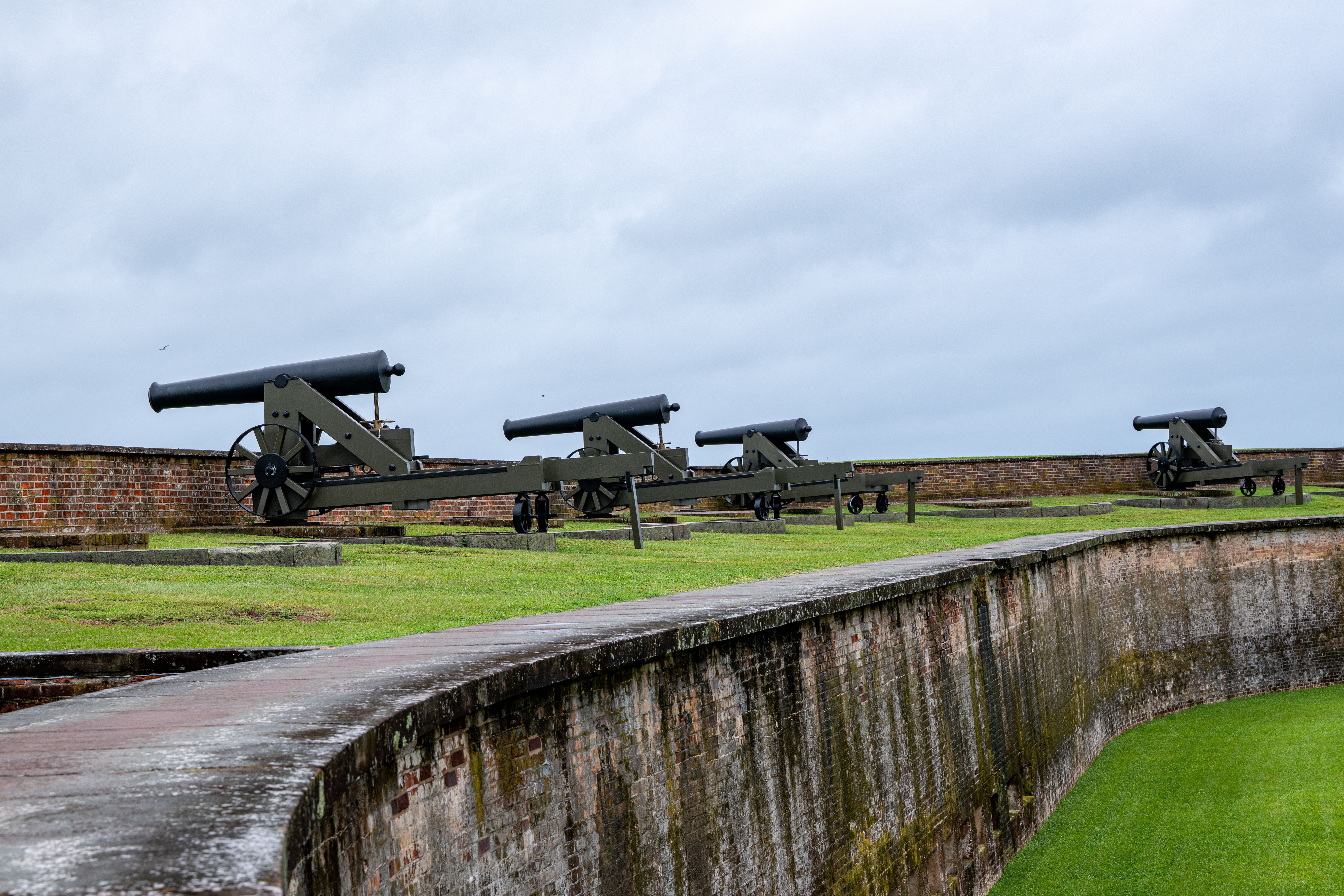 Row of historic cannons overlooking the fort walls at Fort Macon, North Carolina.