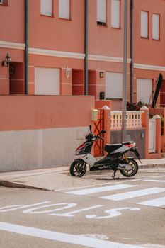 Vibrant urban scene with a moped on a street corner in San Sebastián de La Gomera, Spain.