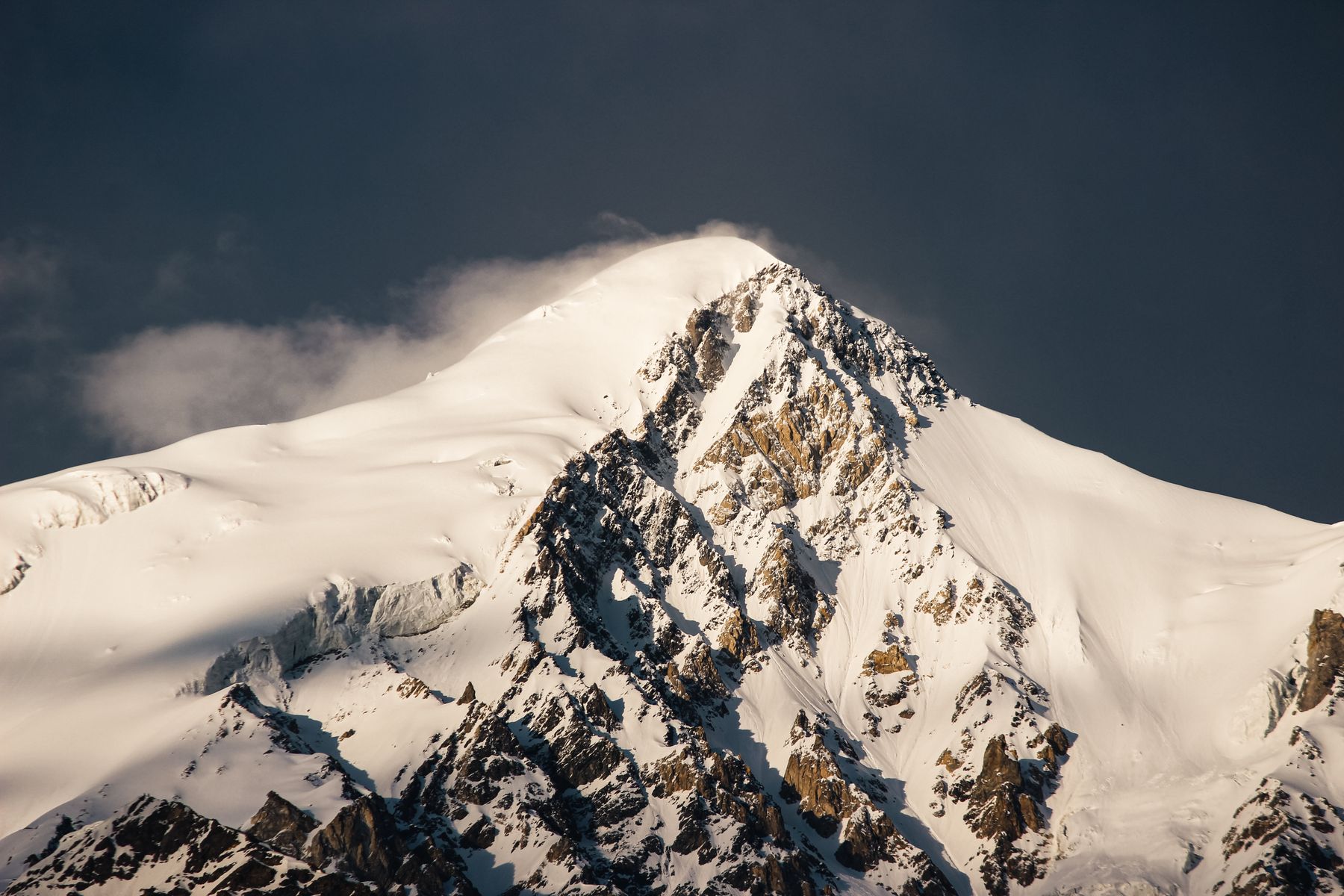 A stunning view of a snow-covered mountain peak under a clear sky in Shigar, Pakistan.
