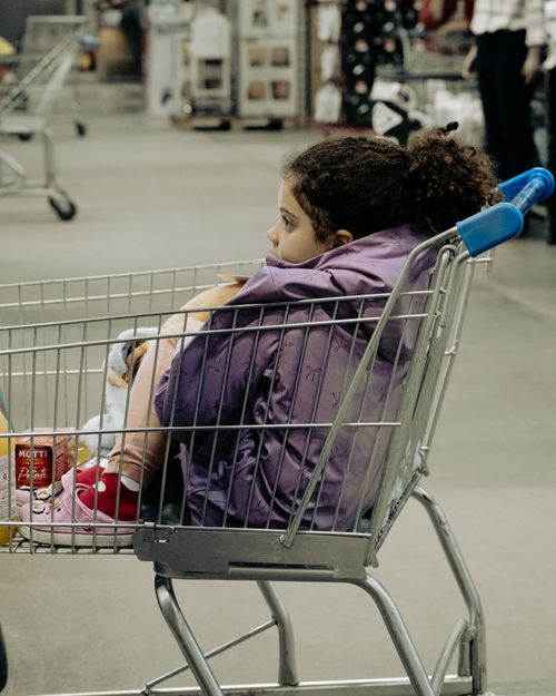Free Child sitting in a shopping cart inside a supermarket in São Paulo, Brazil. Casual and candid moment. Stock Photo