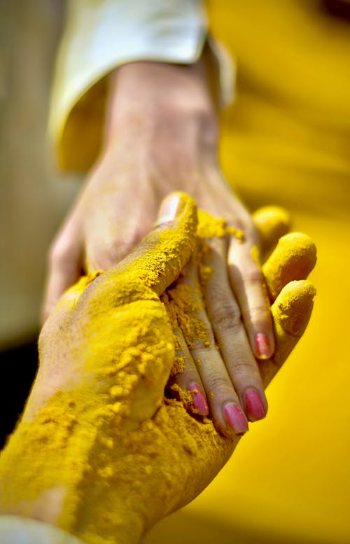 Рука человека покрыта желтым порошком