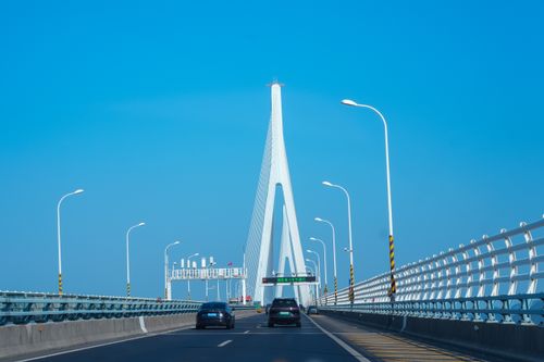 Free A scenic view of the Zhoushan Bridge with vehicles, bright blue sky, and modern architecture. Stock Photo