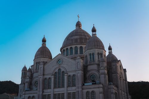 Free Stunning view of a grand cathedral with domed towers against a clear blue sky, symbolizing architectural mastery. Stock Photo