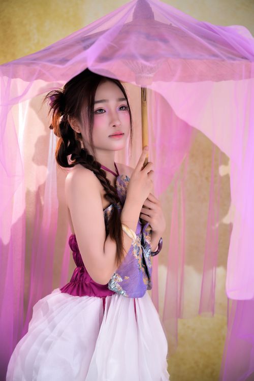 Free A woman in traditional attire holding a pink parasol, creating a dreamy and elegant scene. Stock Photo