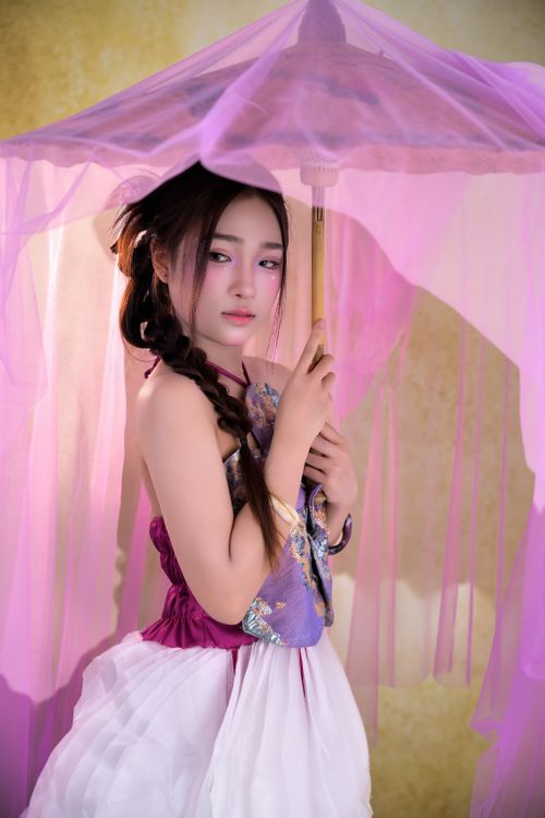 Free Woman in traditional attire holding a parasol, showcasing a blend of elegance and cultural beauty. Stock Photo