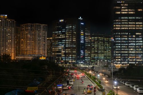 Free A vibrant cityscape at night featuring illuminated skyscrapers and busy streets. Stock Photo