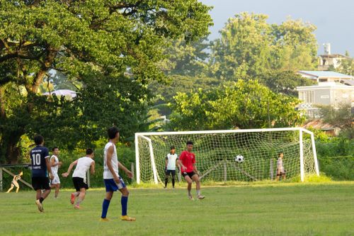 Free Young players engage in a lively soccer match on a sunny day in Myawaddy, Myanmar. Stock Photo
