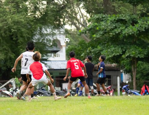 Free Boys playing an engaging football match outdoors in Myawaddy, Myanmar. Stock Photo