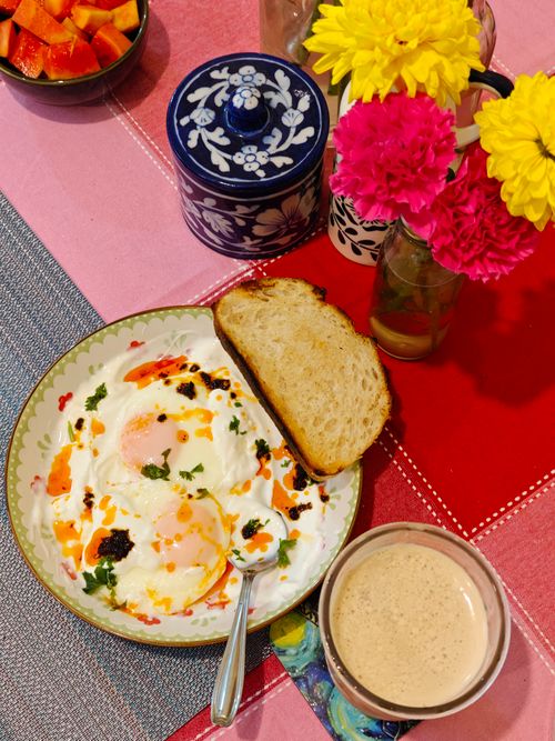 Free Tasty brunch setup with poached eggs, fresh bread, and coffee on a colorful table. Stock Photo
