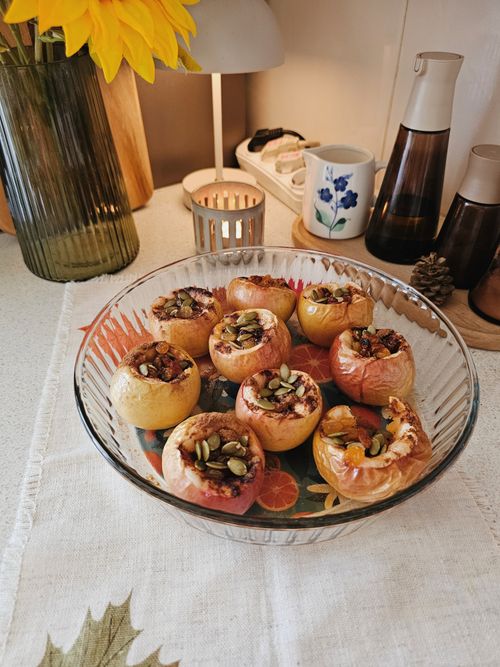 Free Delicious baked apples stuffed with nuts and seeds, presented in a cozy kitchen setting. Stock Photo