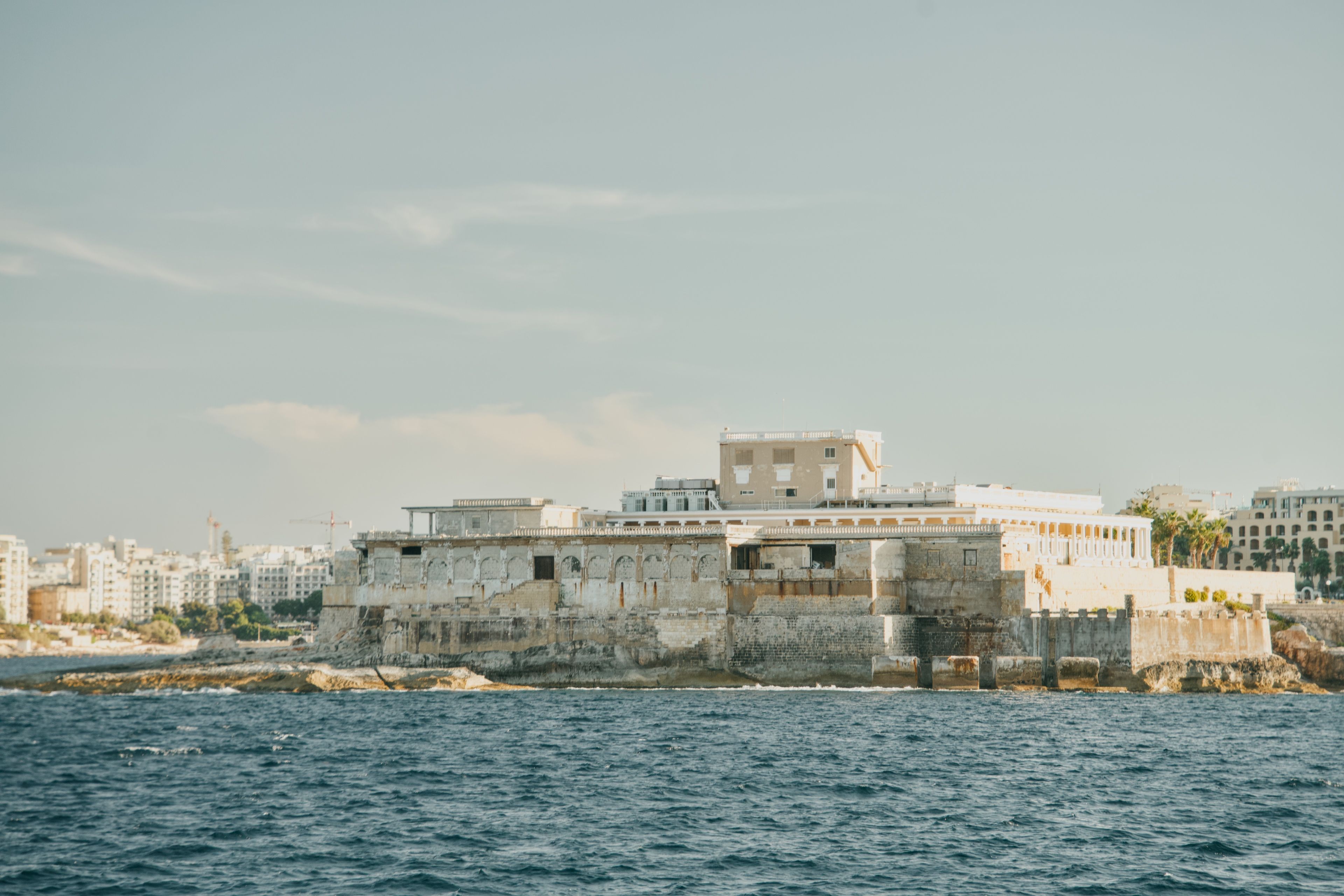 Scenic view of historic fortifications on the coast of Malta, highlighting Mediterranean architecture and maritime landscape.