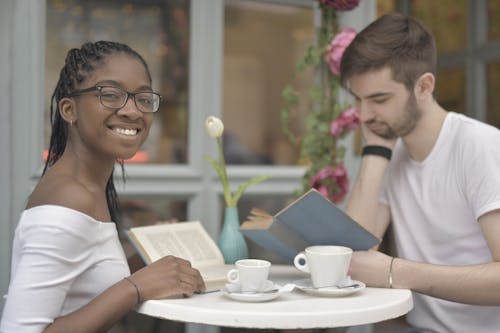 Free Couple Reading Books while Having Coffee Stock Photo