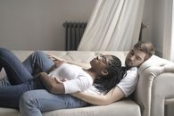 一对多种族夫妇在舒适的室内环境中安静地坐在沙发上休息