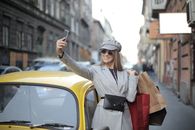 Woman in Gray Coat Holding Black Smartphone