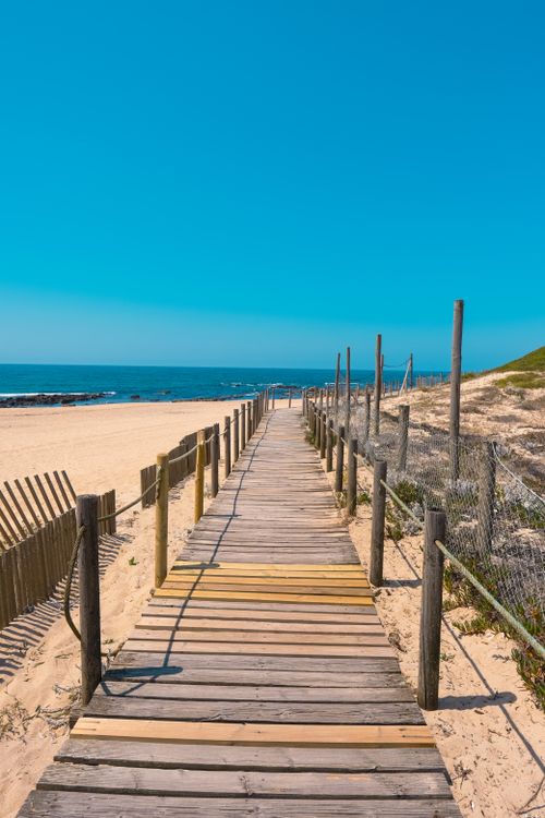 Free Explore the serene beach boardwalk under clear blue skies in Porto, Portugal. Stock Photo