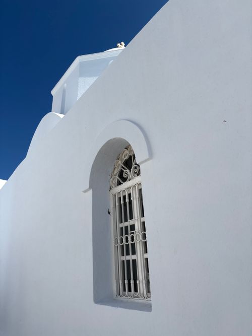 Free Whitewashed building in Santorini, Greece showcasing classic Cycladic architecture under a clear blue sky. Stock Photo