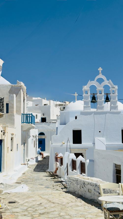 Free Picturesque view of traditional Greek architecture with blue accents in Santorini under a clear blue sky. Stock Photo