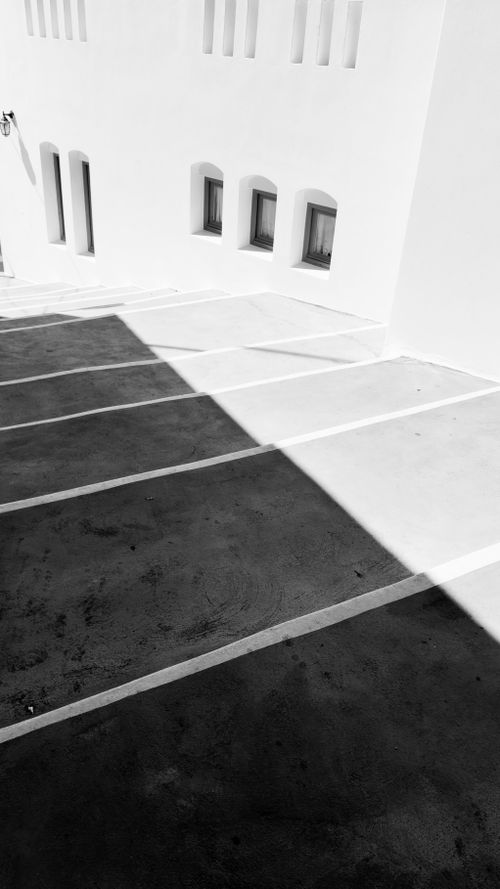 Free Black and white geometric shadows cast on a modern Greek building facade. Stock Photo