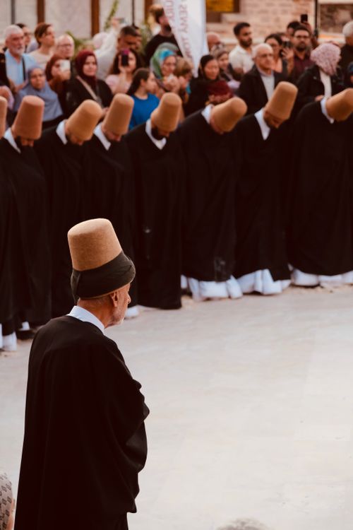Free Mystical Sufi ceremony with whirling dervishes and captivated audience. Stock Photo