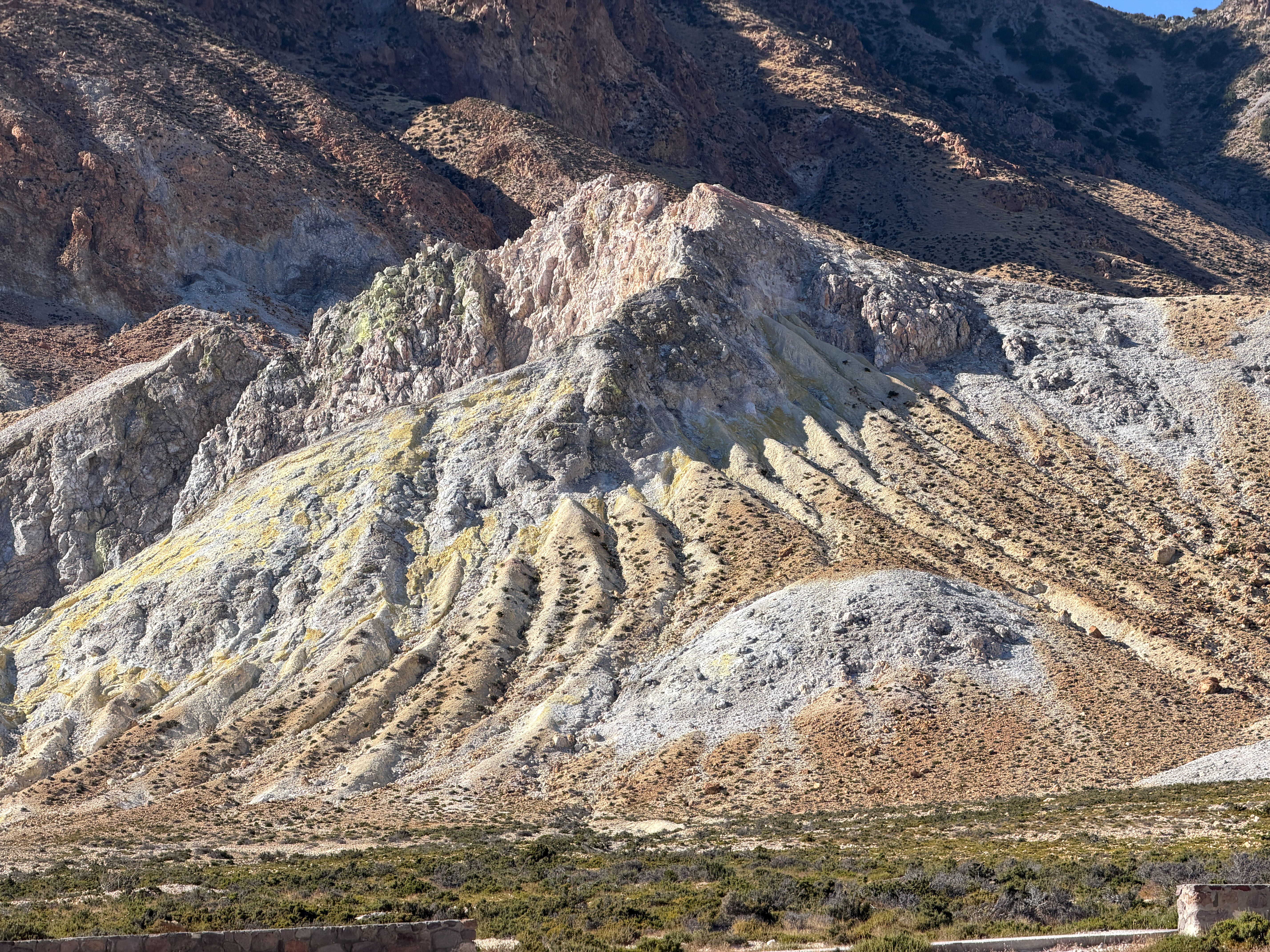 The bare volcanic rock formations of Nisyros, with the caldera beyond.
