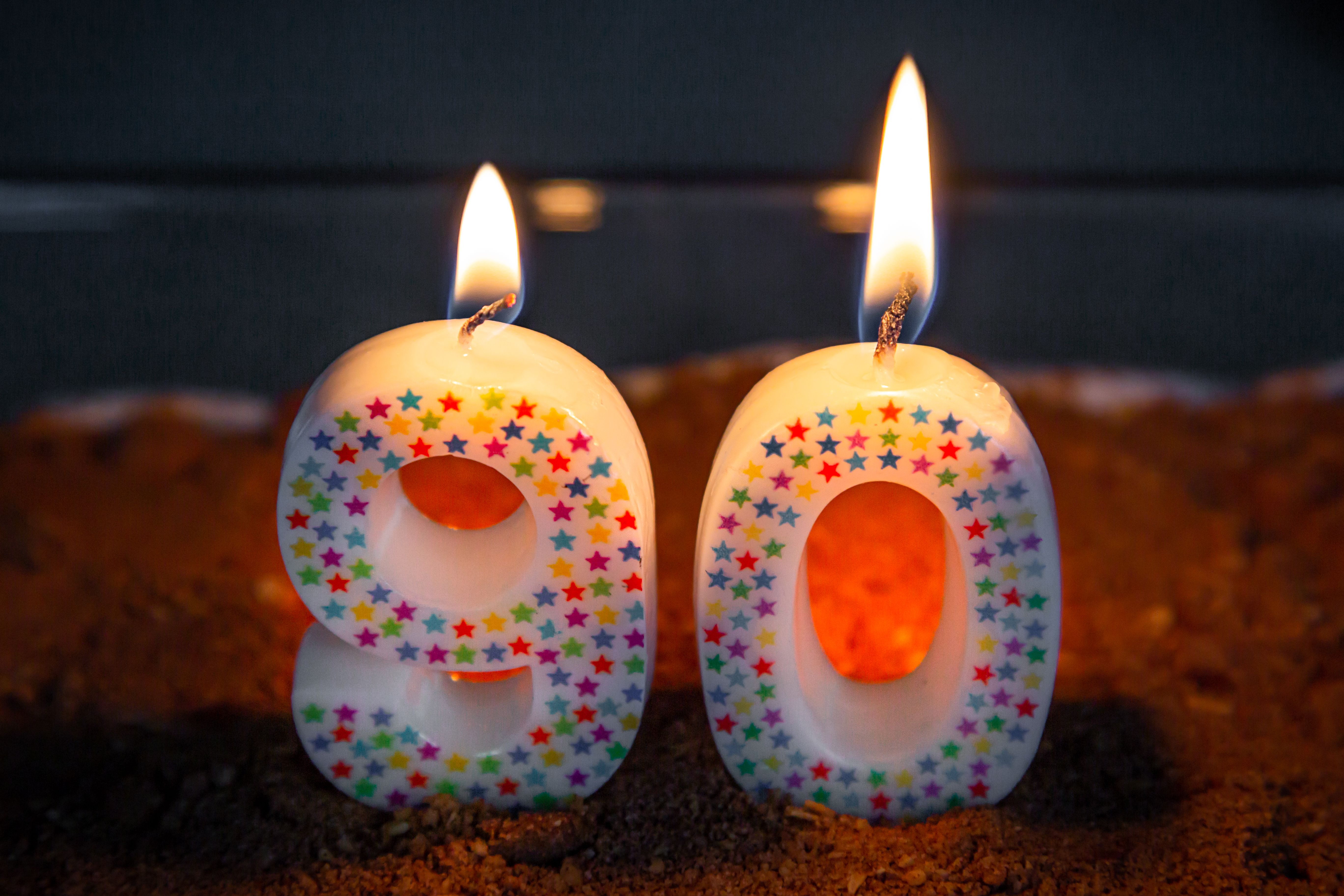 Colorful number 90 birthday candles lit, symbolizing a milestone celebration.