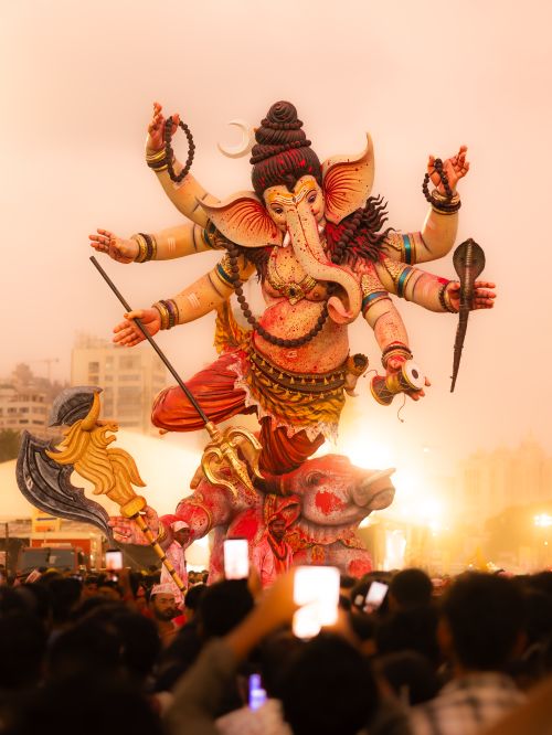 Free Crowd gathered around a giant Ganesh statue during Mumbai's Ganesh Chaturthi festival at dusk. Stock Photo